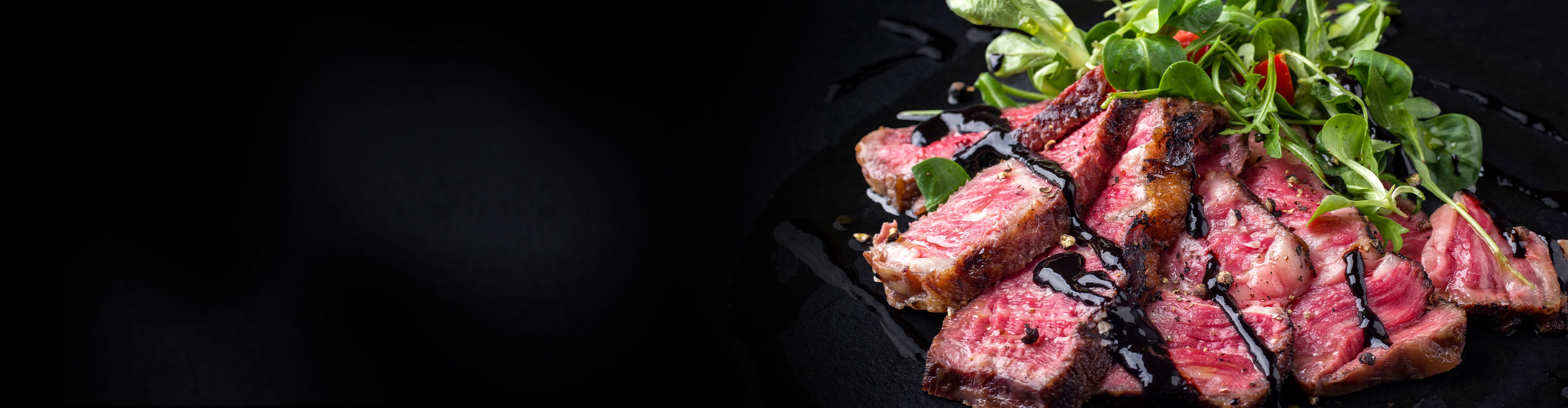 牛肉の薄切りを焼き、ソースをかけ、野菜とともにダークな皿に盛り付けました。