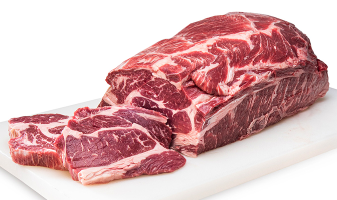 Close-up of sliced beef cuts displayed on a white cutting board.