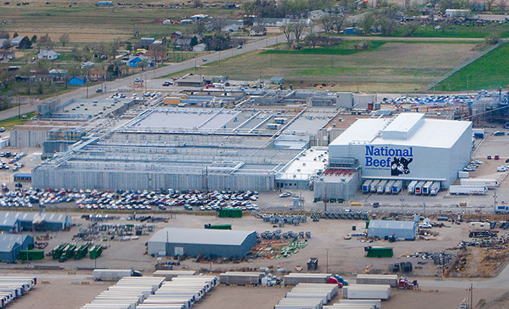 Aerial view of the National Beef processing facility in Dodge City with parking lots and nearby farmland.