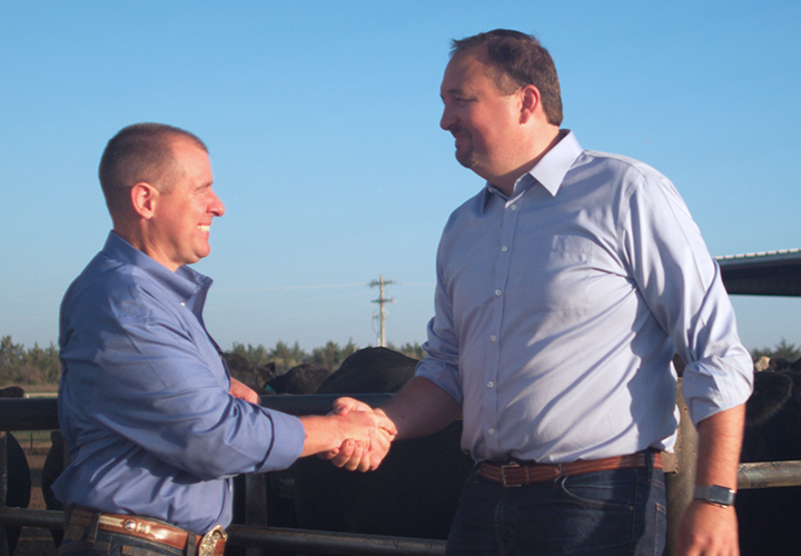 Two men shaking hands outdoors..
