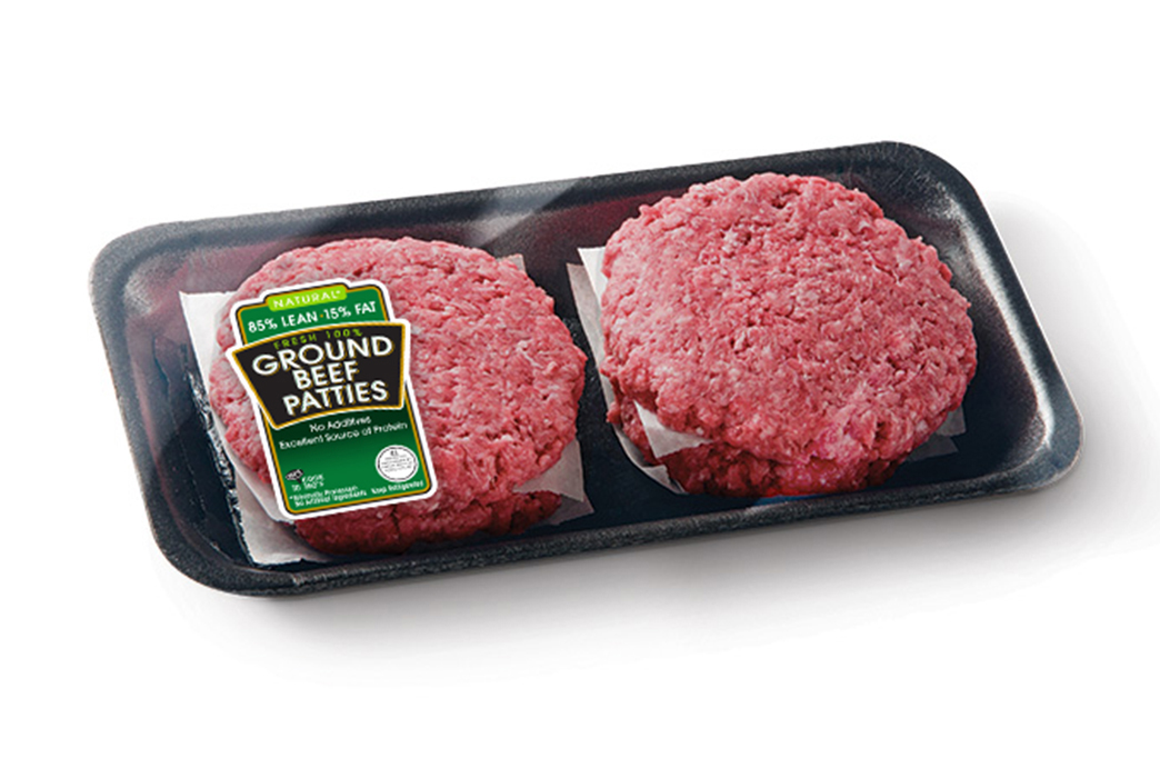 Two raw ground-beef patties in a black tray with label.