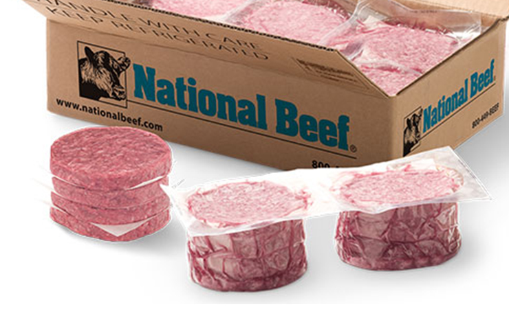 Stacks of packaged beef patties next to a National Beef box.