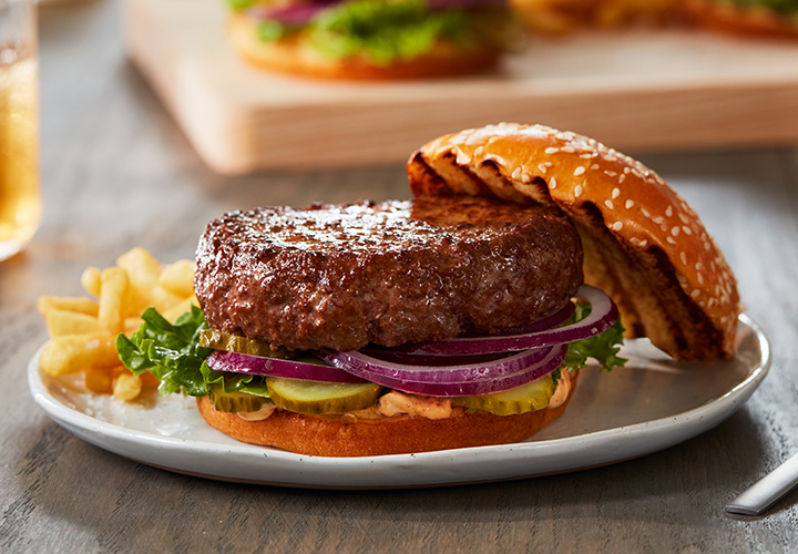 Juicy hamburger with lettuce, pickles and onions.