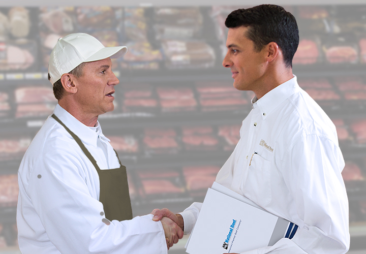 Two professionals in white uniforms shaking hands in front of a meat display counter.