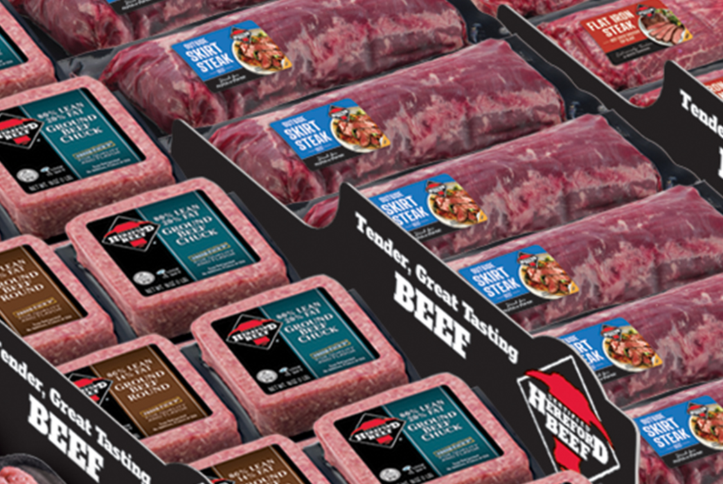 Grocery meat case filled with packaged Certified Hereford Beef ground beef and steak cuts with branded dividers