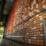 Large warehouse filled with tall racks of stacked boxed products.