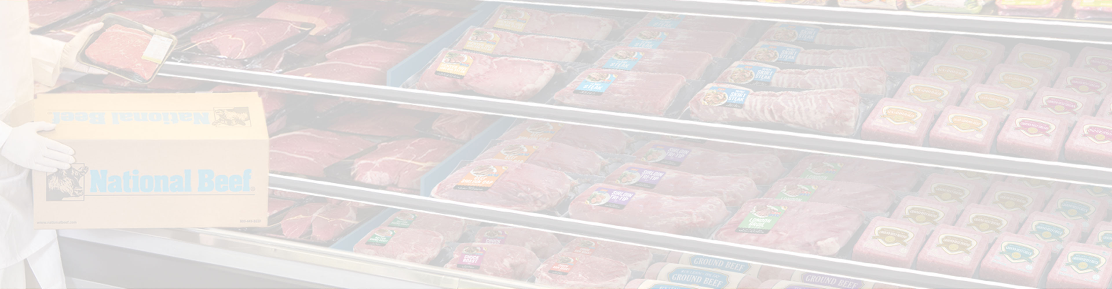 Man holding a National Beef Box stocking a meat case utilizing SmartStock Solutions.