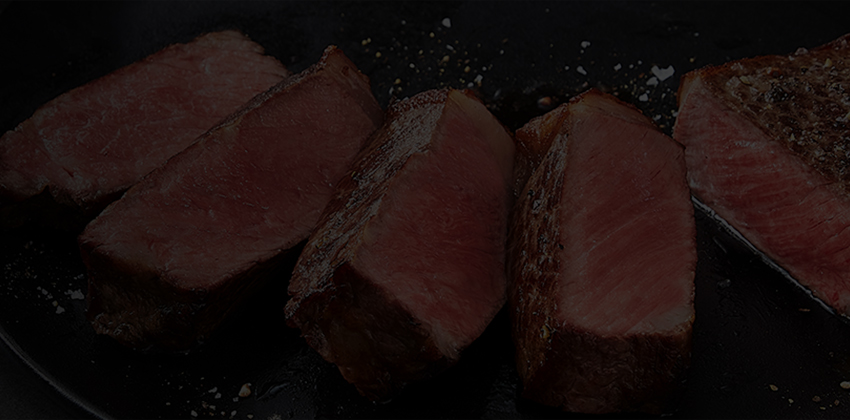 Slices of medium-rare steak in a skillet