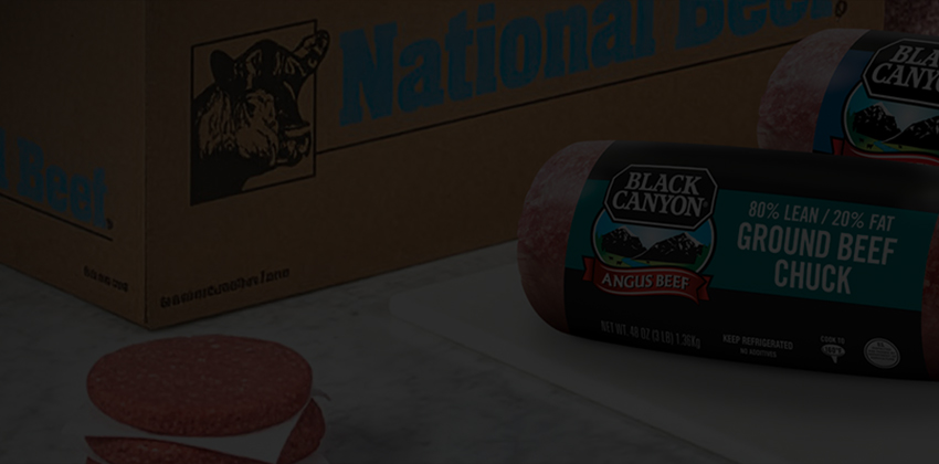 National Beef shipping case with Black Canyon ground beef chubs in front on white surface