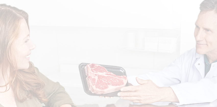 Worker presenting a packaged steak in a bright setting.