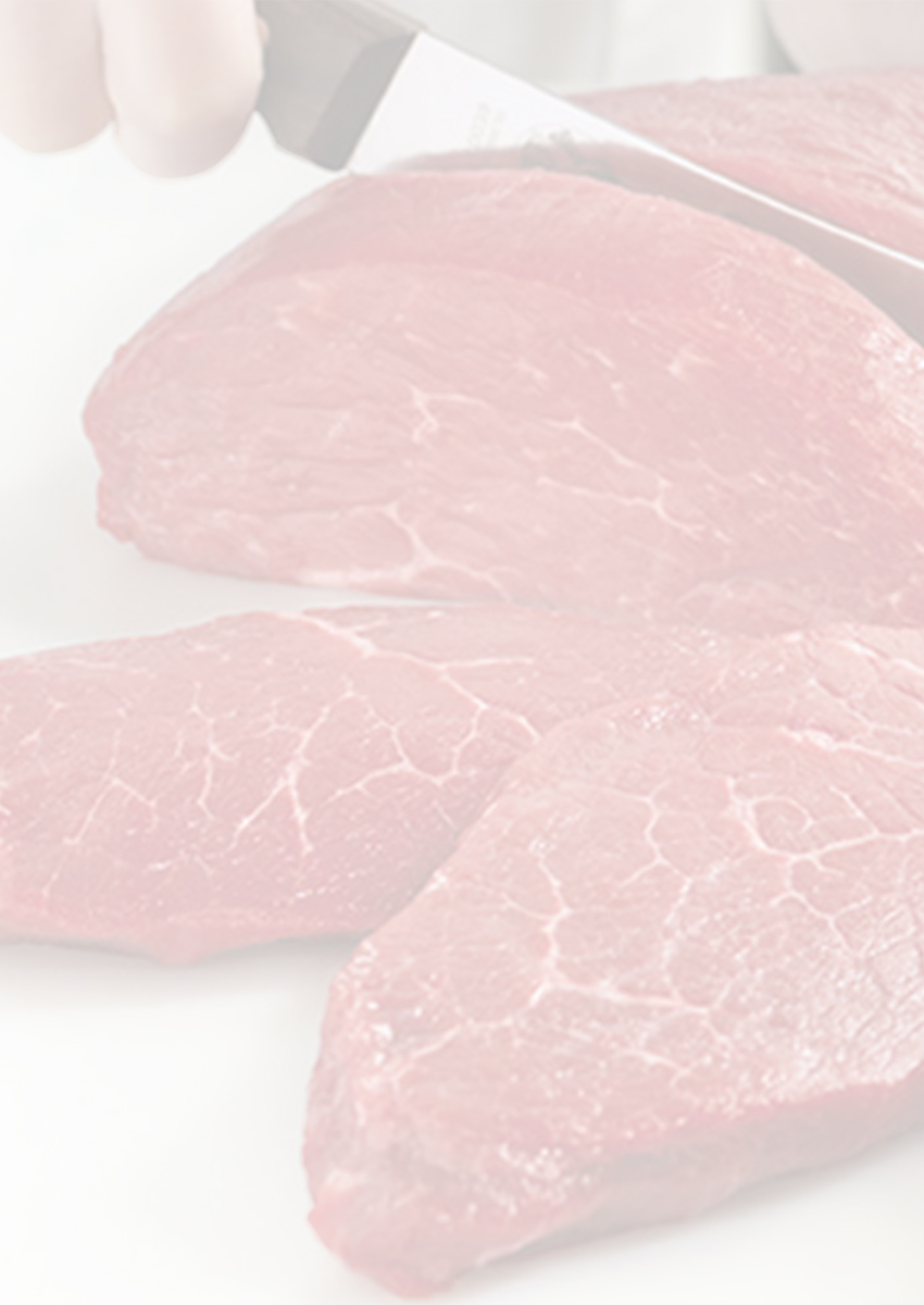 Close-up of raw beef steaks with a knife held above them.