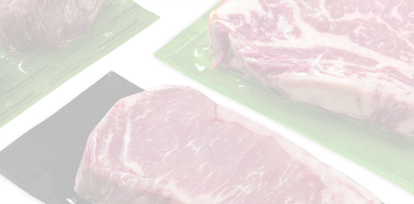 Vacuum-sealed steaks in black and green packaging.