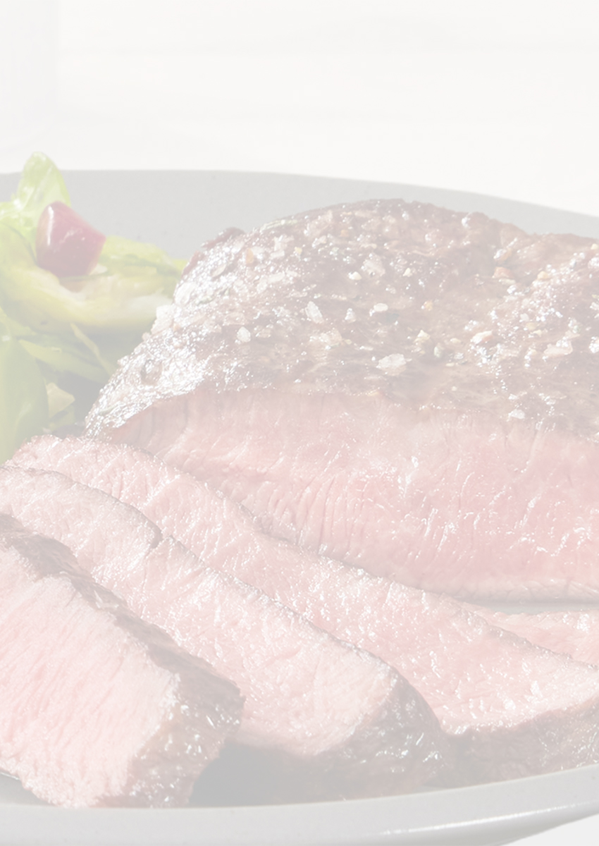 Flat Iron steak on a silver plate with a small side salad.