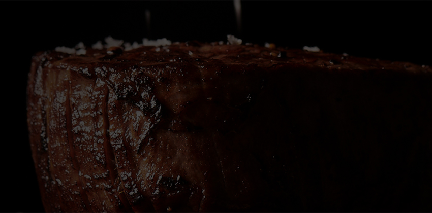 Filet on dark background with salt being sprinkled on top.