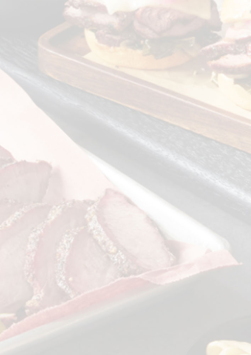 Light overlay image showing assorted cooked meats and sides.